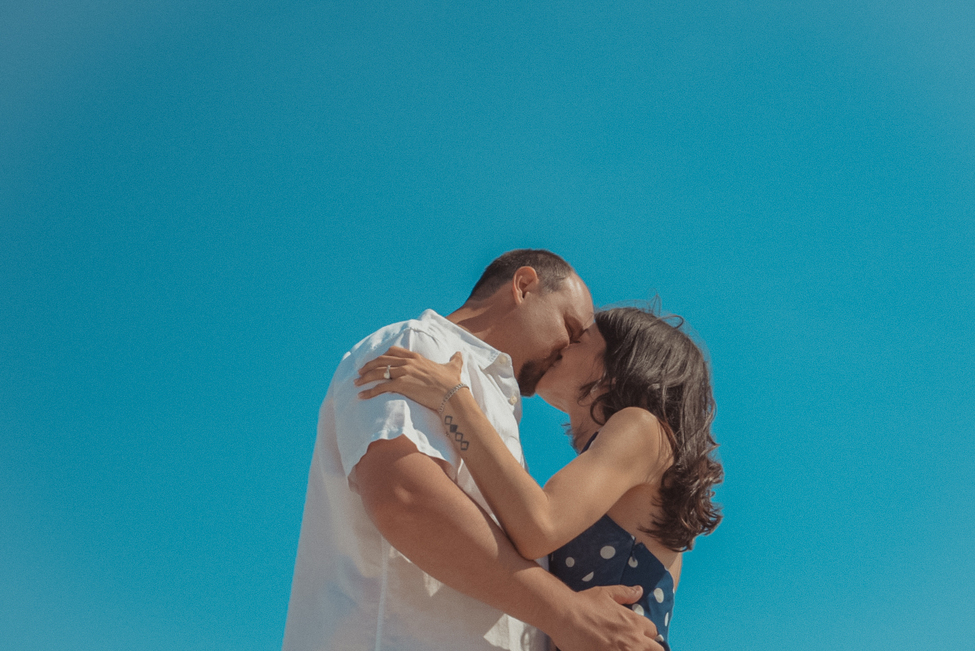 Couple kissing against blue sky